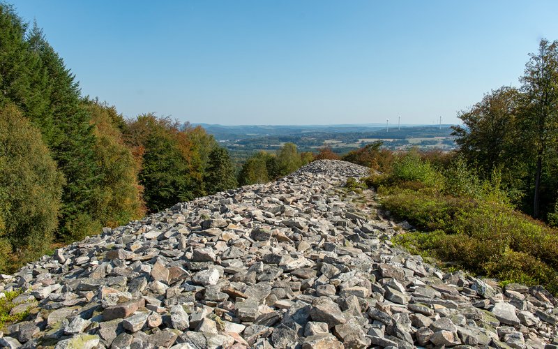 Der keltische Ringwall ist ein Steinwall, der über 2.000 Jahre alt und 10 Meter hoch ist. Er liegt mitten im Wald.