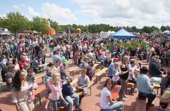 Vor dem Musikpavillon sind Bänke aufgestellt, auf denen die Familien Platz nehmen und die aufgeführten Shows verfolgen können.