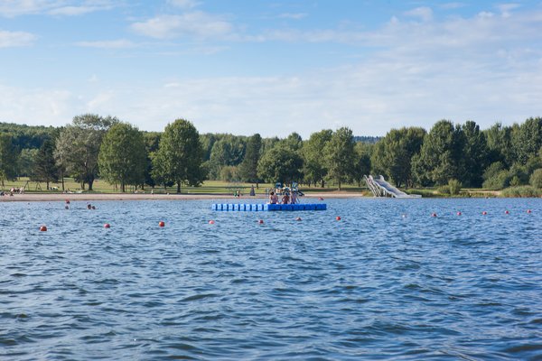Der Schwimmbereich im Strandbad Bosen ist durch Bojenketten abgegrenzt. Im Wasser selbst befindet sich eine blaue Badeinsel.